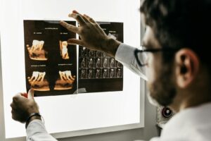personne en chemise grise à manches longues tenant une tablette noire