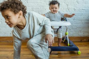 Deux jeunes enfants profitent d'un moment de jeu ensemble dans un cadre intérieur chaleureux, explorant et créant des liens joyeux.
