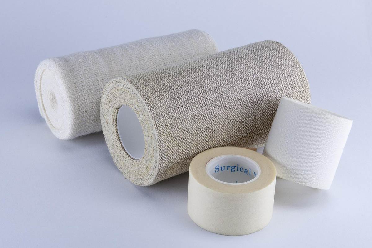 Rouleaux de bandage et bande adhésive posés sur fond clair Rouleaux de bandage et bande adhésive posés sur fond clair