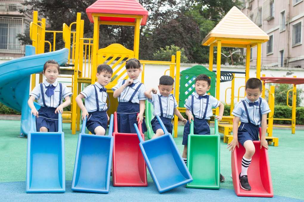 Enfants sur des toboggans colorés dans un parc de jeux